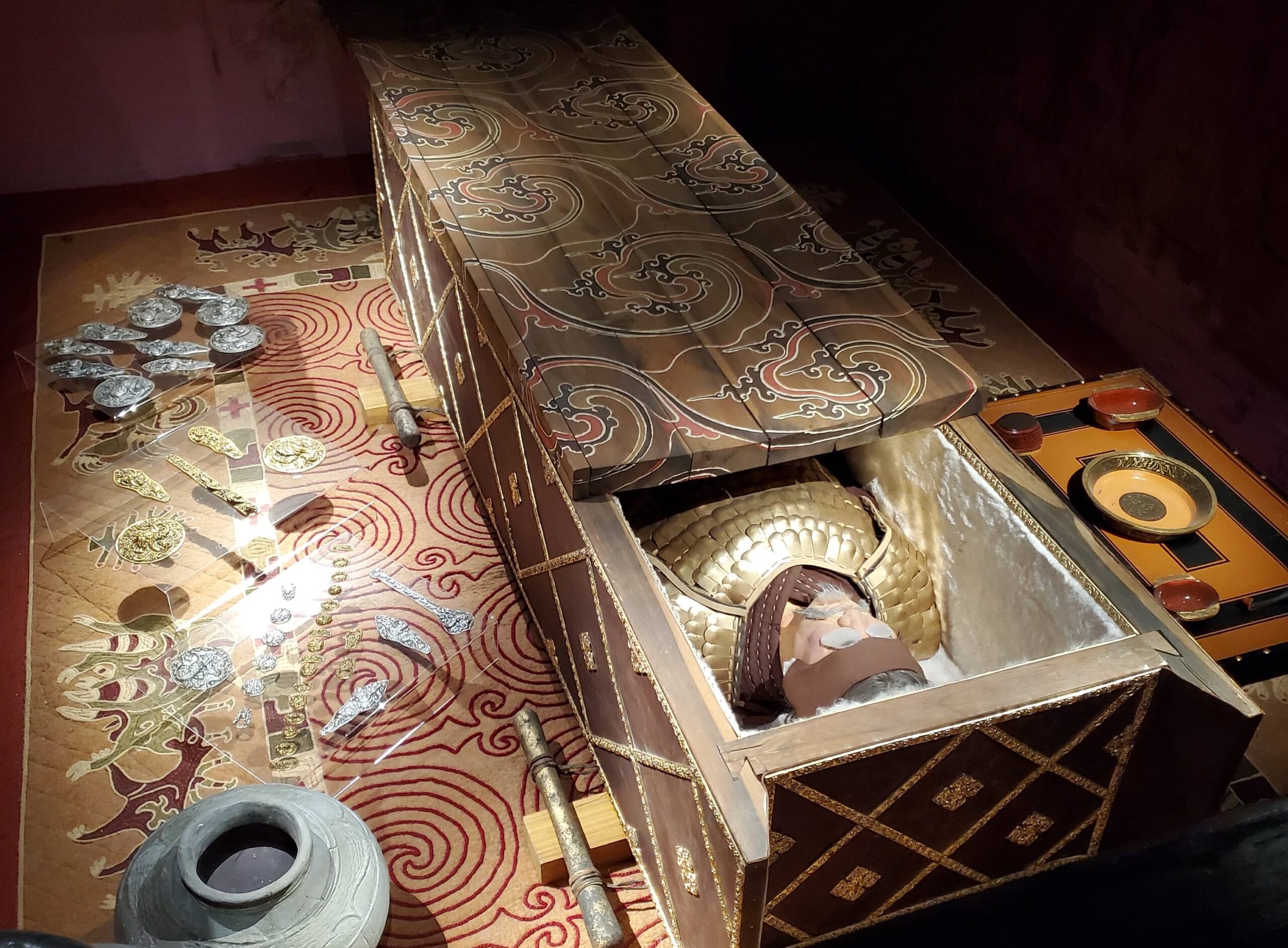 A photo of an archaeological museum display featuring a recreation of an ancient burial site.