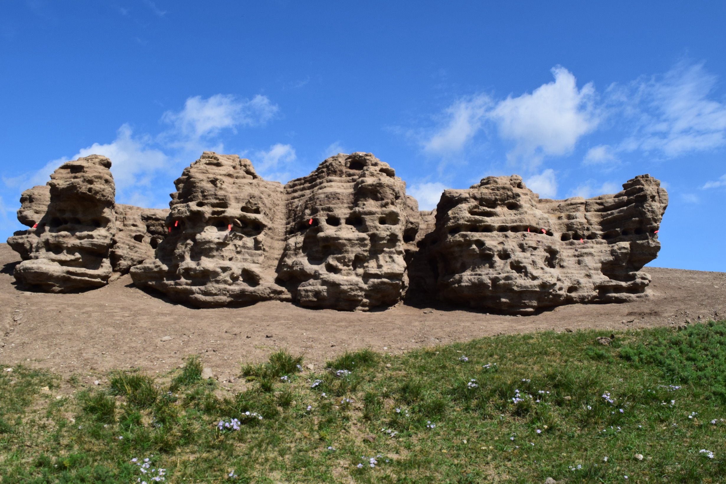 Pitted rock formations stand in the Mongolian steppe.